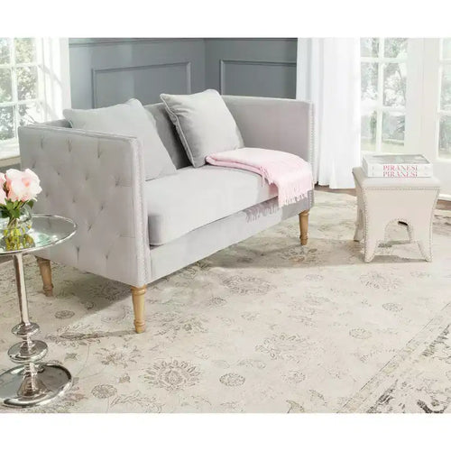 Causeuse capitonnée en velours gris avec coussins décoratifs